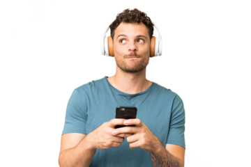 Brazilian man over isolated chroma key background listening music with a mobile and thinking