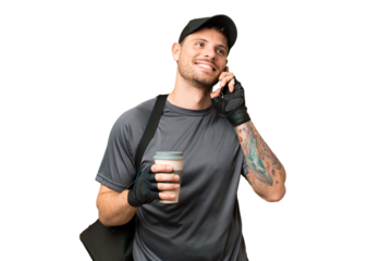 Young sport man with sport bag over isolated chroma key background holding coffee to take away and a mobile