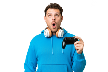 Brazilian man playing with a video game controller over isolated chroma key background looking up and with surprised expression