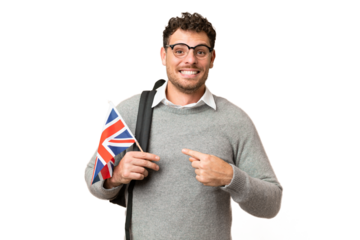 Brazilian man holding an United Kingdom flag over isolated chroma key background with surprise facial expression