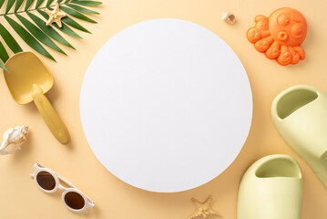 Enjoy beach weekend with your little one. Top view of sandcastle kit, eyewear, comfy flip-flops, shells, starfish, palm leaf on soft beige backdrop. Empty circle great for family-focused ad or promo