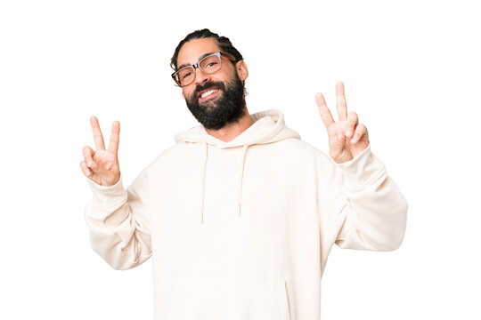 Young man with beard over isolated chroma key background showing victory sign with both hands