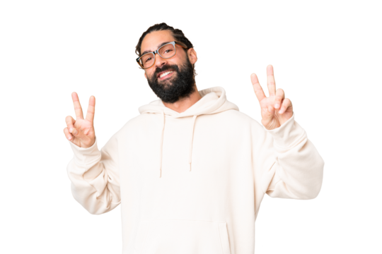 Young man with beard over isolated chroma key background showing victory sign with both hands