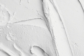 Decorative white putty background. Wall texture with filler paste applied with spatula, chaotic...