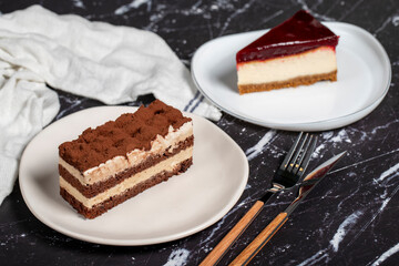 Tiramisu and cheesecake on dark background. delicious cakes