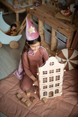 little girl dressed as a sorceress in a scandinavian children's room. © Маргарита Медведева