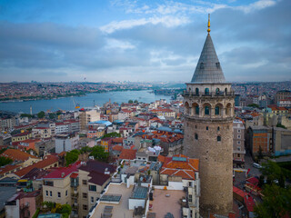 Galata Tower aerial view with morning twilight with Golden Horn at back in Beyoglu in historic city of Istanbul, Turkey. Historic Areas of Istanbul is a UNESCO World Heritage Site since 1985. 
