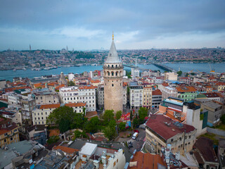 Galata Tower aerial view with morning twilight with Golden Horn at back in Beyoglu in historic city of Istanbul, Turkey. Historic Areas of Istanbul is a UNESCO World Heritage Site since 1985. 