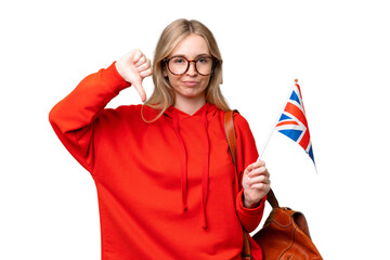 Young hispanic woman holding an United Kingdom flag over isolated background showing thumb down