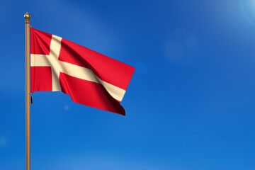 Denmark.  Flag blown by the wind with blue sky in the background