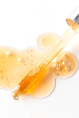 Dropper pipette with bubbles drops, Cosmetic swatch of collagen, enzyme, ceramide, hyaluronic acid and peptides on white background. Anti aging face product