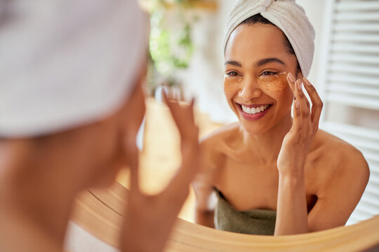 Woman applying eye mask on dark circles