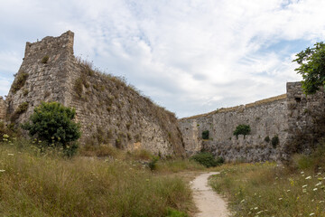 Fototapeta na wymiar Stone wall fortifications in moat of old town of Rhodes, Greece