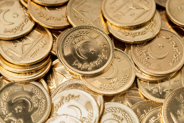 Stacks of gold coins of Pakistani currency symbolize wealth and prosperity