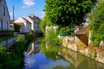Obraz premium Flowered embankment of the Grand Morin river in Crécy la Chapelle, a village of the French department of Seine et Marne in Paris region often nicknamed 
