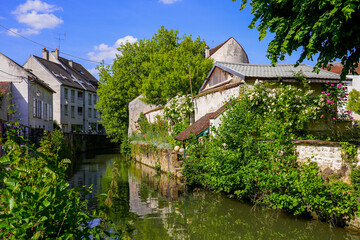 Obraz premium Flowered embankment of the Grand Morin river in Crécy la Chapelle, a village of the French department of Seine et Marne in Paris region often nicknamed 