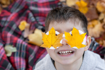 adorable cute preschooler boy with glasses frame wizard shape with leaves fall leaf glued...