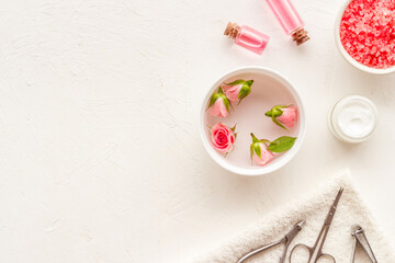 Manicure set with roses water in bowl. Herbal hands care cosmetic set.