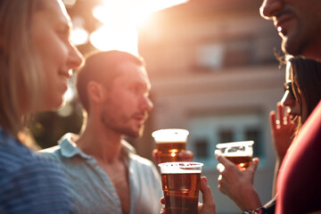 Group of friends enjoying cold beer at a backyard party.