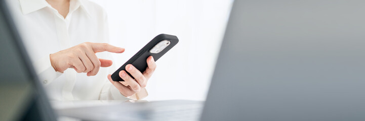 The woman works at home and uses a smart phone and a notebook laptop computer. Silhouette of a busy woman. She holds and using phone.