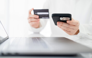 Women holding credit card and using smartphones at home.Online shopping, internet banking, store online, payment, spending money, e-commerce payment at the store, credit card, concept