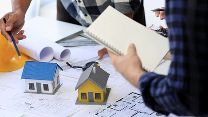 The home design architects are reviewing the house plan draft, the project commissioned by the client, and the custom design before delivery. Interior design and decoration ideas.	