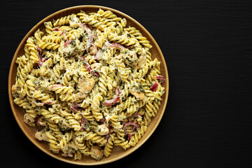 Homemade Creamy Lemon Butter Chicken Pasta on a Plate on a black background, top view.