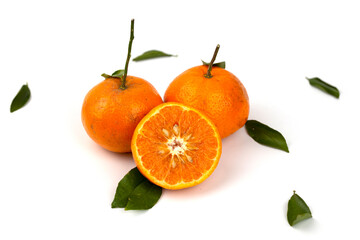 An orange fruit, orange slices, and orange leaves are isolated on a white background.
