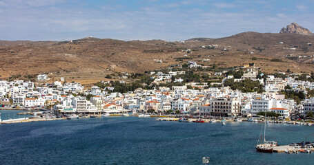 Fototapeta na wymiar Greece Tinos island Cyclades. View from ship of Chora town cafe, building, port, sea, blue sky.