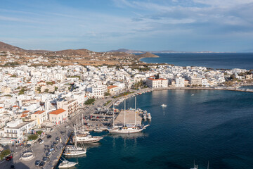 Greece Tinos island Hora town Cyclades. Aerial drone view of port moored ship, Aegean sea blue sky.