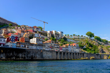 Porto, Portugal old town skyline from across the Douro River. Colorful facades of houses in the old district Cais da Ribeira