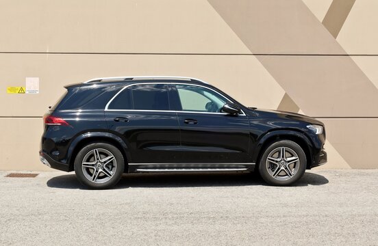 Udine, Italy. June 15, 2023. Black Mercedes Benz  GLE 450 on brown painted modern wall background. Side view.