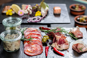 a table topped with different types of food, meat and vegetables