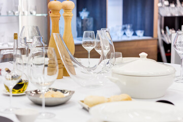 interior of a kitchen assortent shop / hotel or restaurant assortment shop / table set with wine glasses, plates and silverware