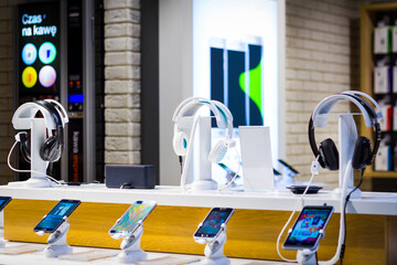 interior of a modern electronic shop row of cell phones and headphones sitting on top of a table