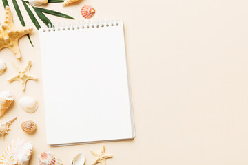 Blank writing book with summer beach accessories on background, copy space. Flat lay with copy space