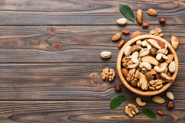 Obraz na płótnie Canvas mixed nuts in bowl. Mix of various nuts on colored background. pistachios, cashews, walnuts, hazelnuts, peanuts and brazil nuts
