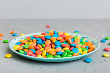 Multicolored candies in a bowl on a colored background. birthday and holiday concept. Top view with copy space