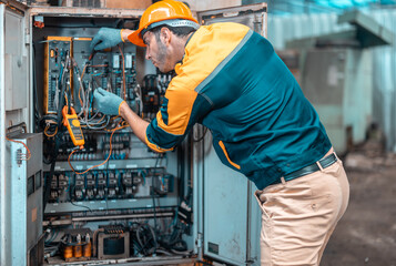 Electrical technician tests wiring, polarity, grounding, voltages and performs electrical maintenance using hand tools that involve clamp meter, screwdriver, and cutter. The foreman's routine tasks.