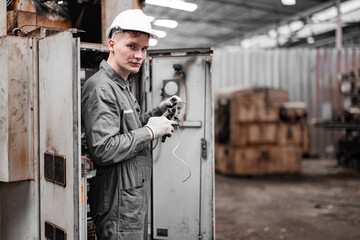 Electrical technician tests wiring, polarity, grounding, voltages and performs electrical maintenance using hand tools that involve clamp meter, screwdriver, and cutter. The foreman's routine tasks.