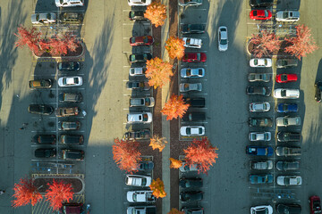 Aerial view of many colorful cars parked on parking lot with lines and markings for parking places...