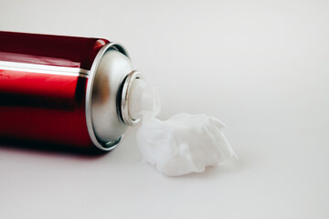 Red metal packaging with shaving foam on a white background