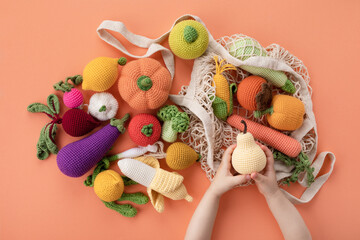 Children hands with cute knitting vegetables and fruits for activity, motor and sensory...