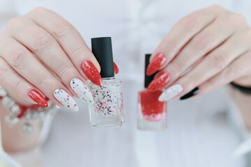 Female hands with long nails and bright red and white manicure