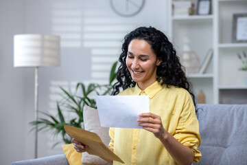 Joyful and happy woman at home received mail envelope with notification, hispanic woman reading...