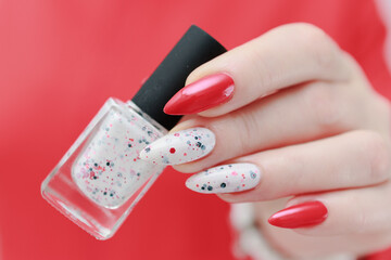 Female hands with long nails and bright red and white manicure