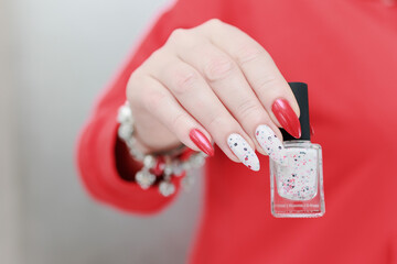 Female hands with long nails and bright red and white manicure