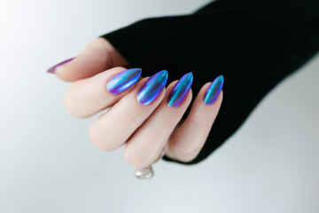 beautiful female hand with long nails, purple and blue manicure 
