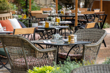 Before lunch time, empty stylish cafes with served tables waiting for guests in sunny Saint-Tropez, Provence, France