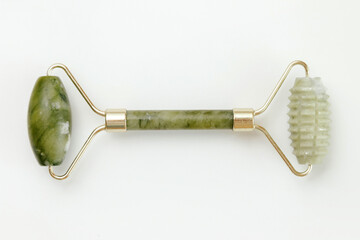 Facial jade massage roller made of green quartz stone on white background. - obrazy, fototapety, plakaty